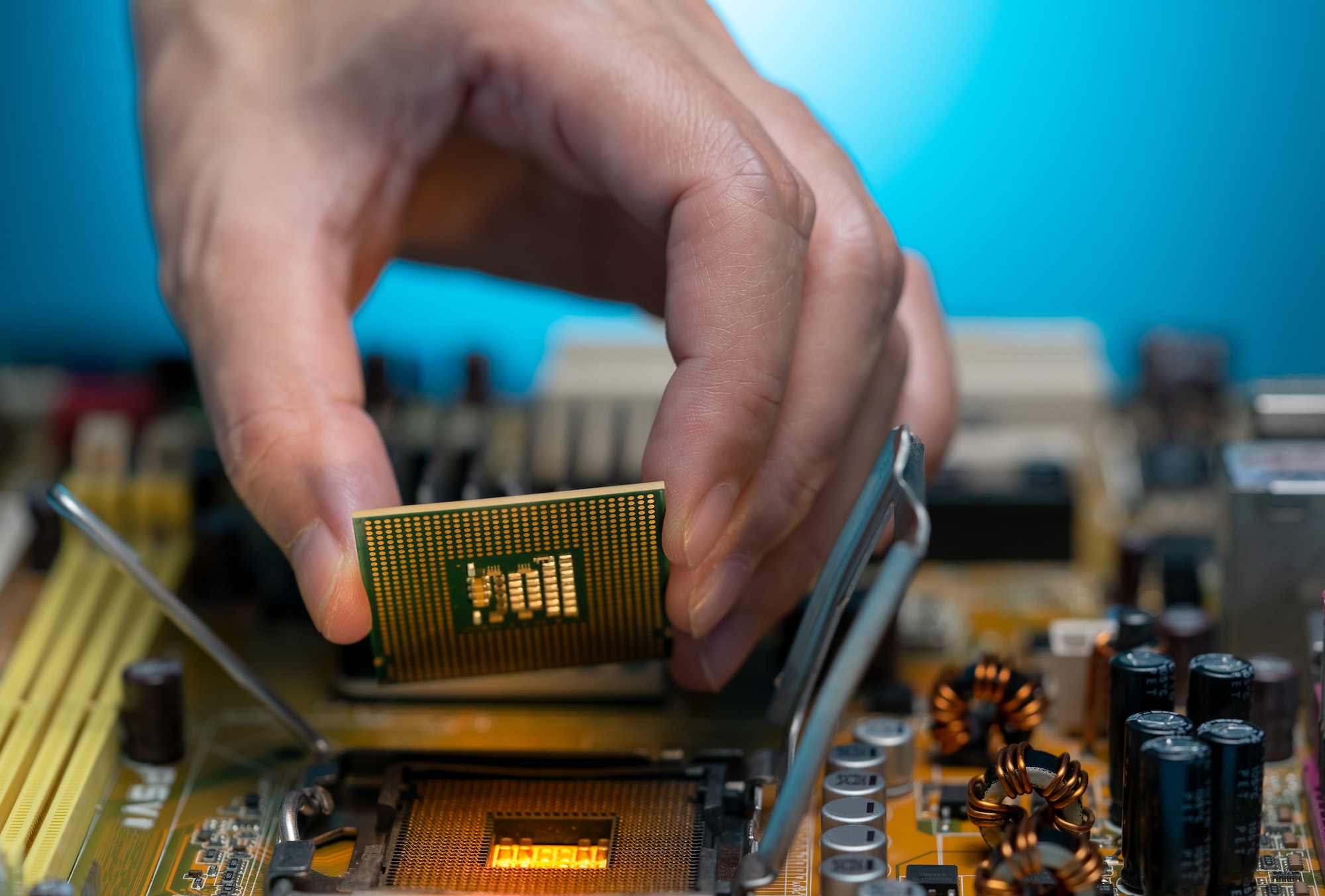 Electronic engineer hand putting computer chip on socket. Chipset on electronic circuit board of PC