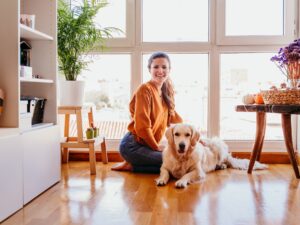 beautiful woman hugging her adorable golden retriever dog at home. love for animals concept