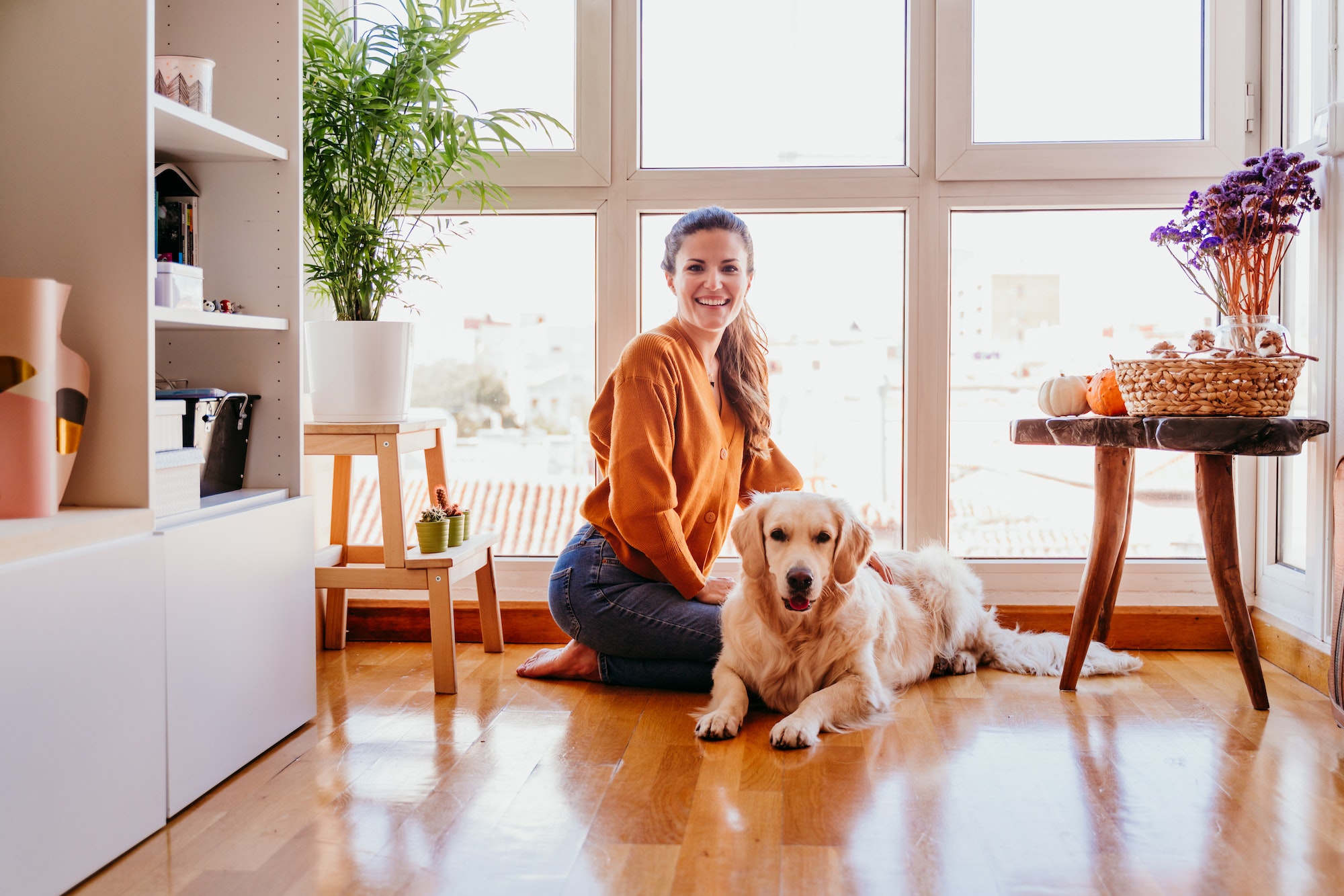 beautiful woman hugging her adorable golden retriever dog at home. love for animals concept