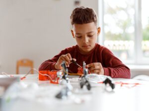 Kid constructing model with constructor details in school
